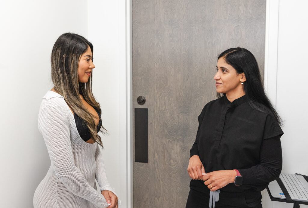 A female patient speaks with a provider at WellnestMD about her options for arm skin tightening near Brookhaven.
