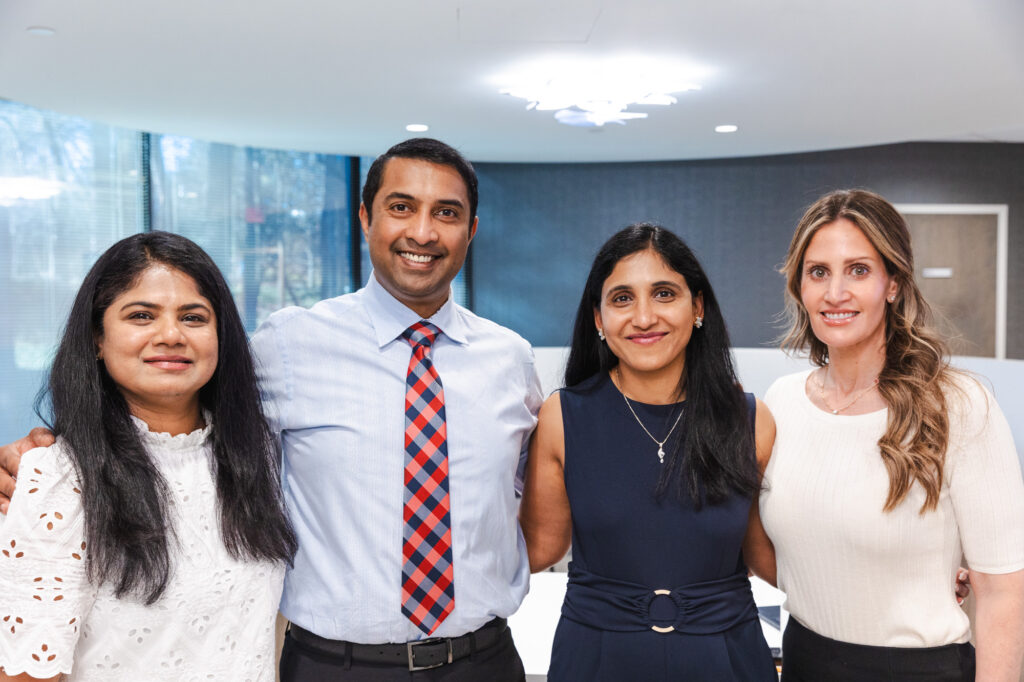 The team at Wellnest MD smiles in the front of their clinic, where they help patients find sore throat remedies in Sandy Springs.