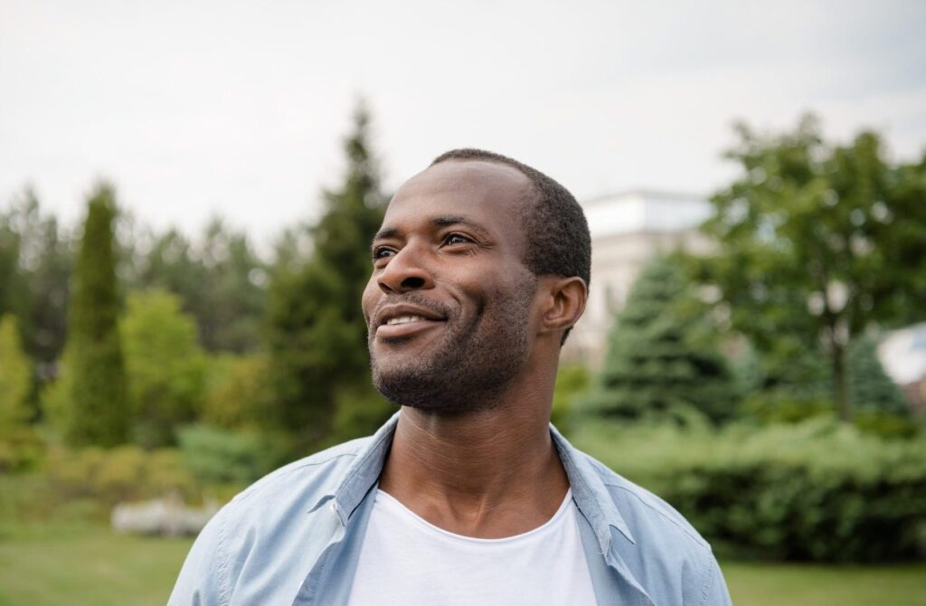 Portrait of smiling african american man looking away in park after getting Hormone Therapy Near Brookhaven.