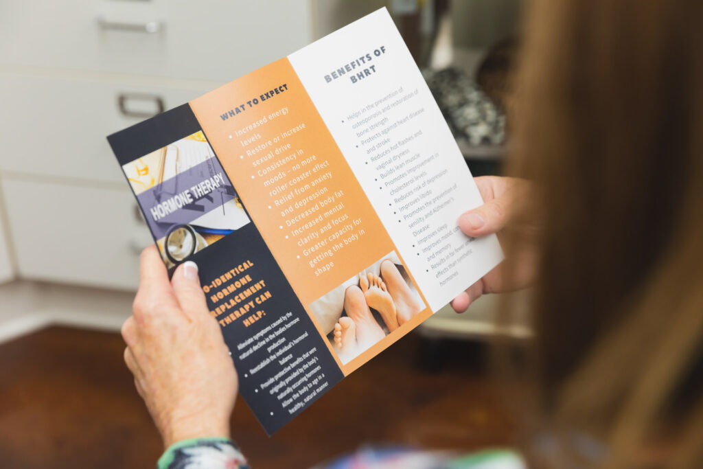 Close up of a patient holding a pamphlet about hormone therapy for menopause treatment near Brookhaven.