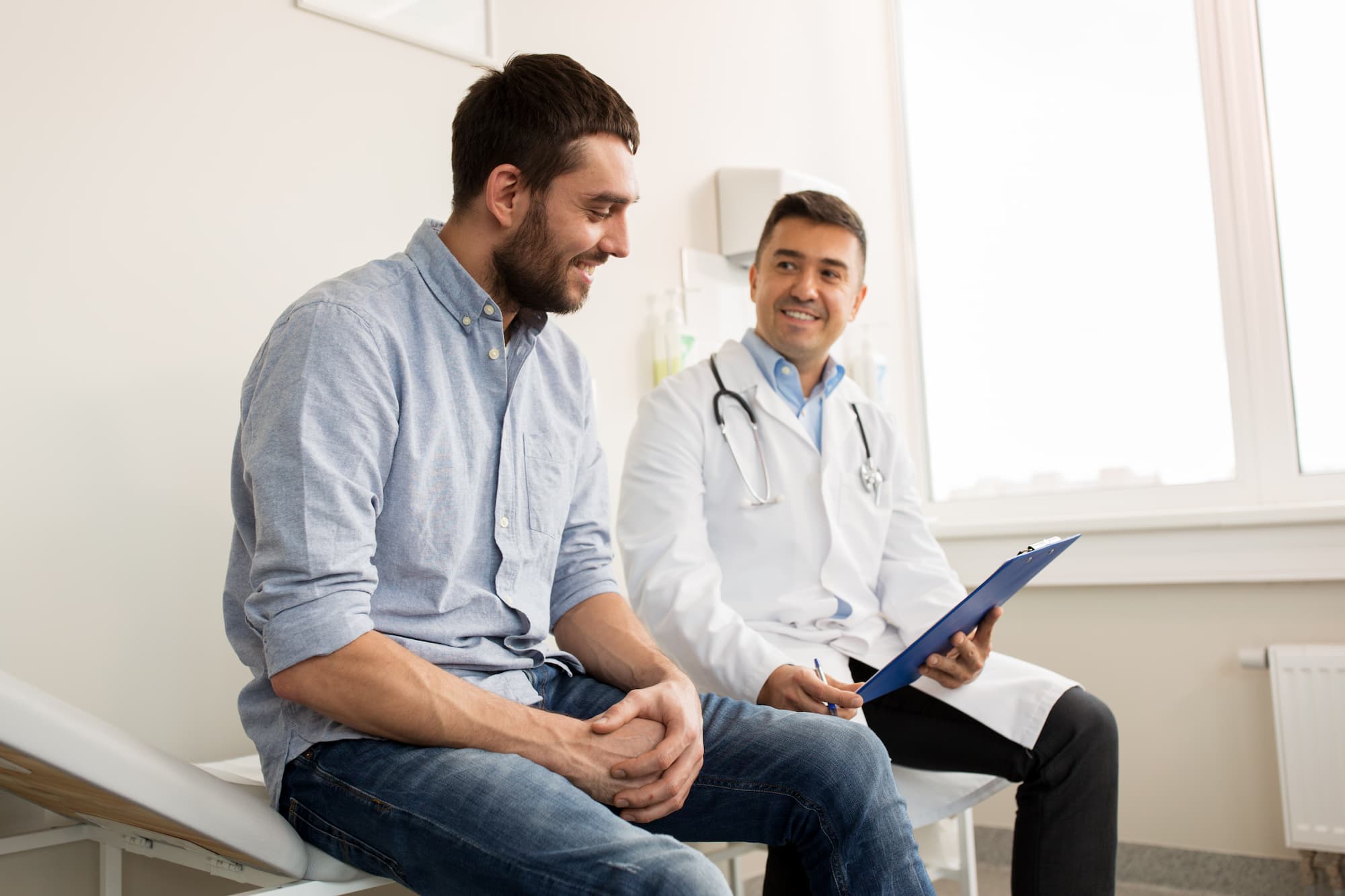 A physician speaking with a male patient in a medical office about Hormone Therapy Near Brookhaven.